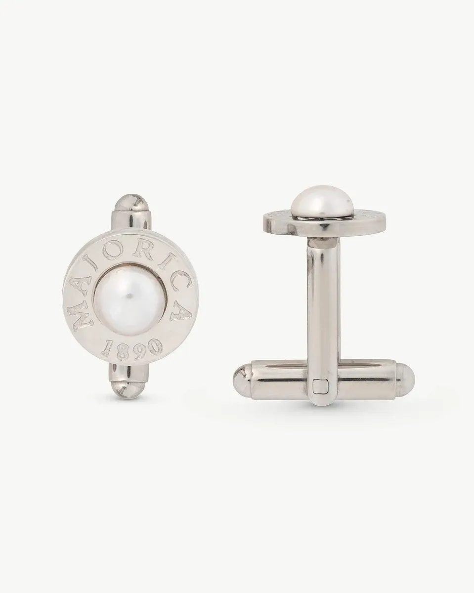 Paire de boutons de manchette en acier avec demi-perle blanche, vue de face et de profil sur fond blanc.