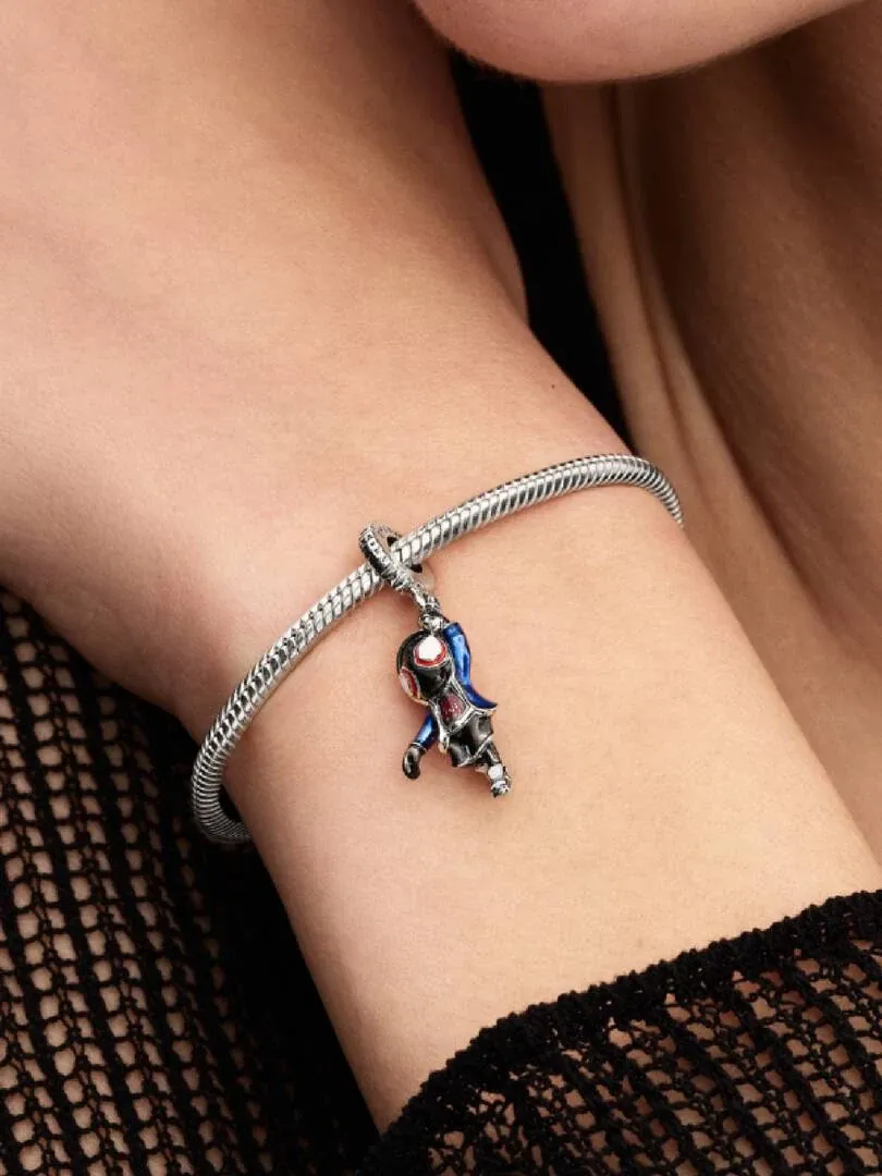 Primer plano del charm de Spider-Man en una pulsera de plata, sobre la muñeca con prenda negra de red.