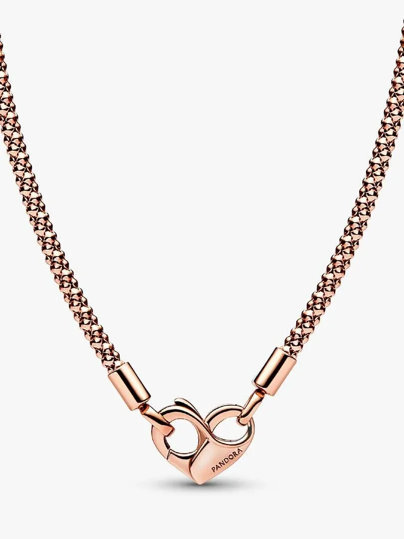 Close-up of the rose gold heart and infinity clasp on a white background, front view.
