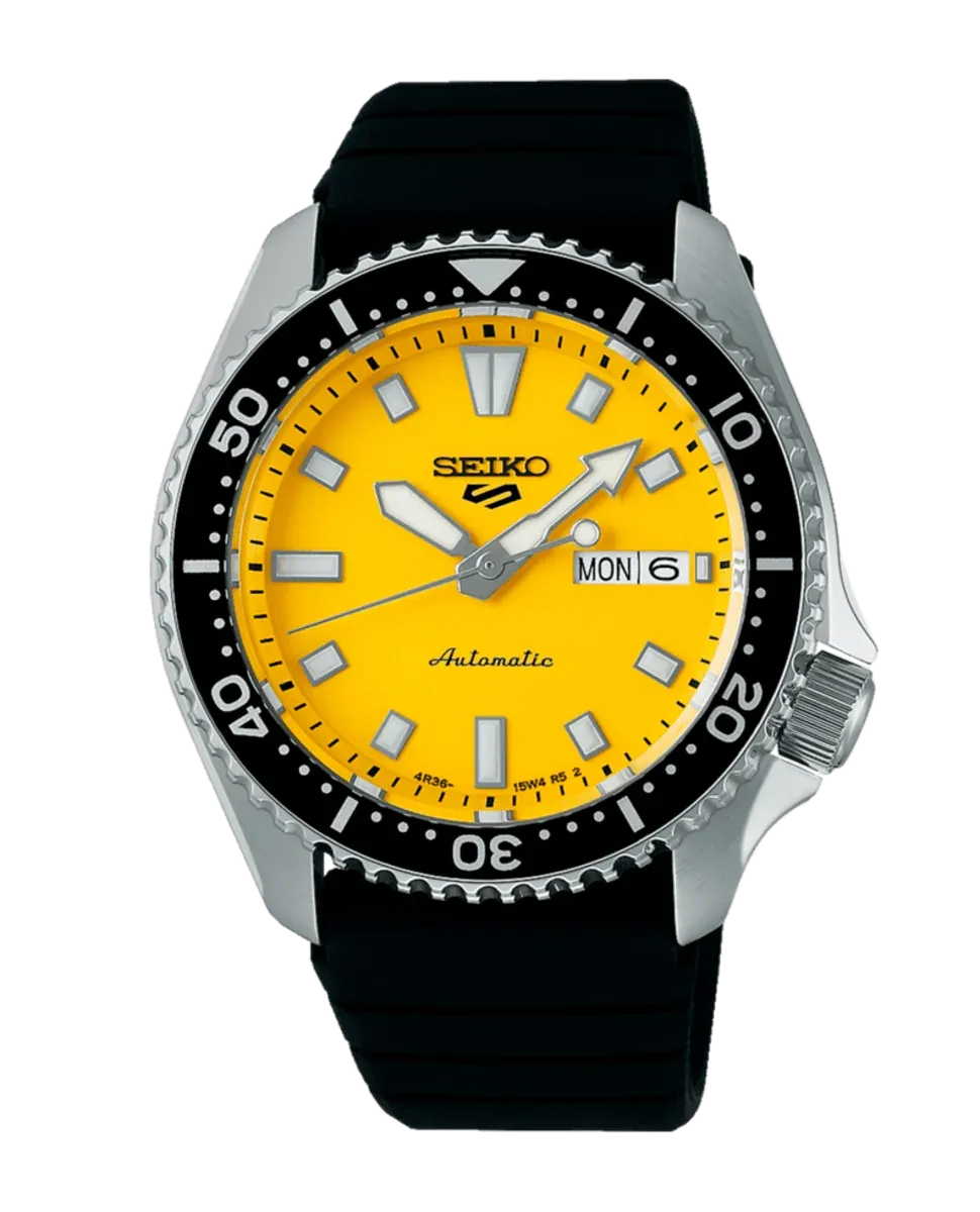 Vista frontal completa del reloj con esfera amarilla y correa negra sobre fondo blanco.