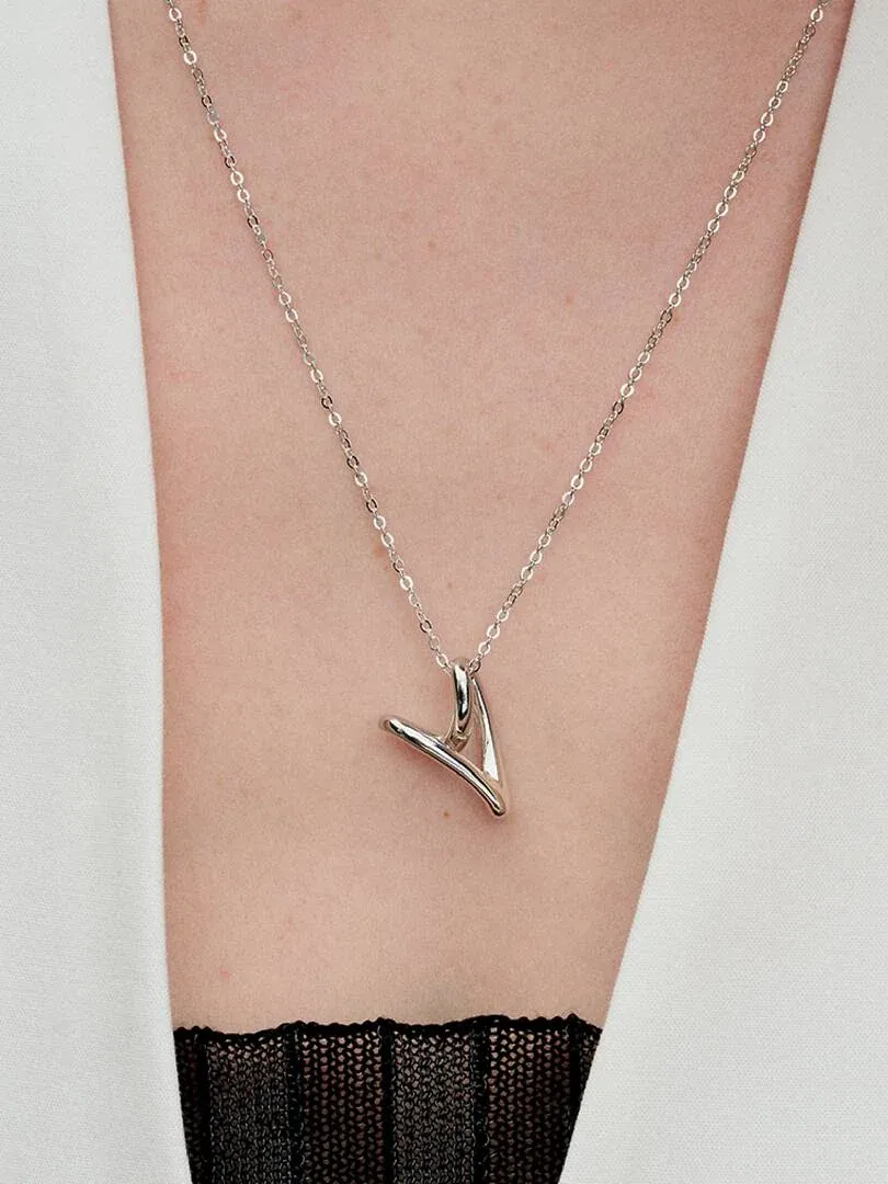 Gros plan du collier en argent sur le cou d'un mannequin, vue de face sur fond neutre.