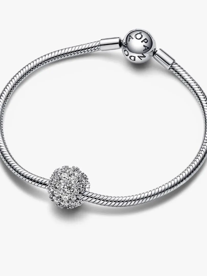Sphärischer Pavé-Charm an einem Silberarmband, schräge Frontansicht, weißer Hintergrund.