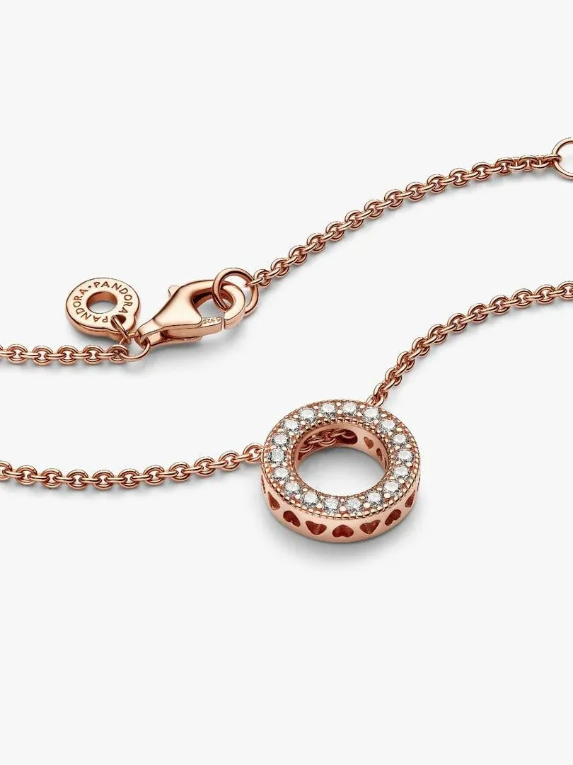 Roségoldene Halskette mit Pavé-Kreisanhänger auf weißem Hintergrund, diagonale Ansicht.