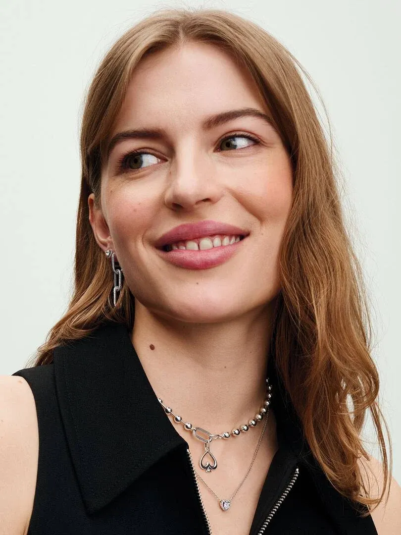 Close-up of link and bead necklace on model's neck, front view against a light neutral background.