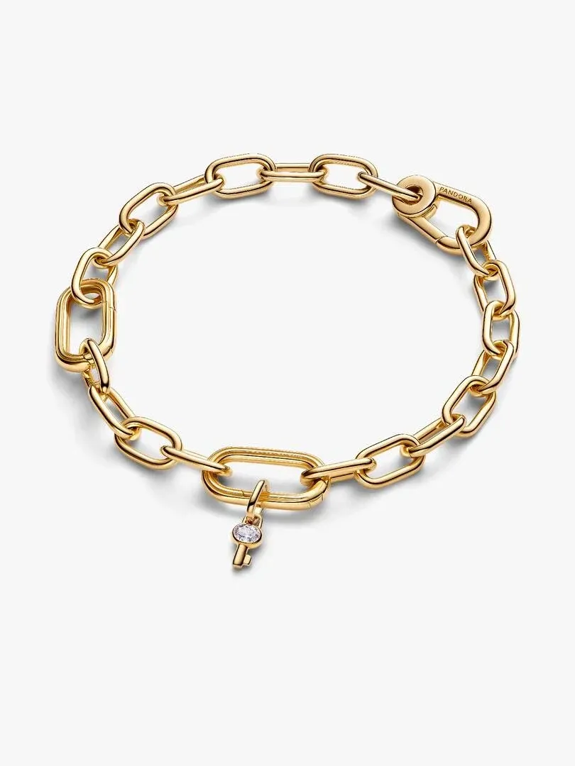 Gouden schakelarmband van bovenaf gezien op een witte achtergrond, met de sleutelhanger op de voorgrond.