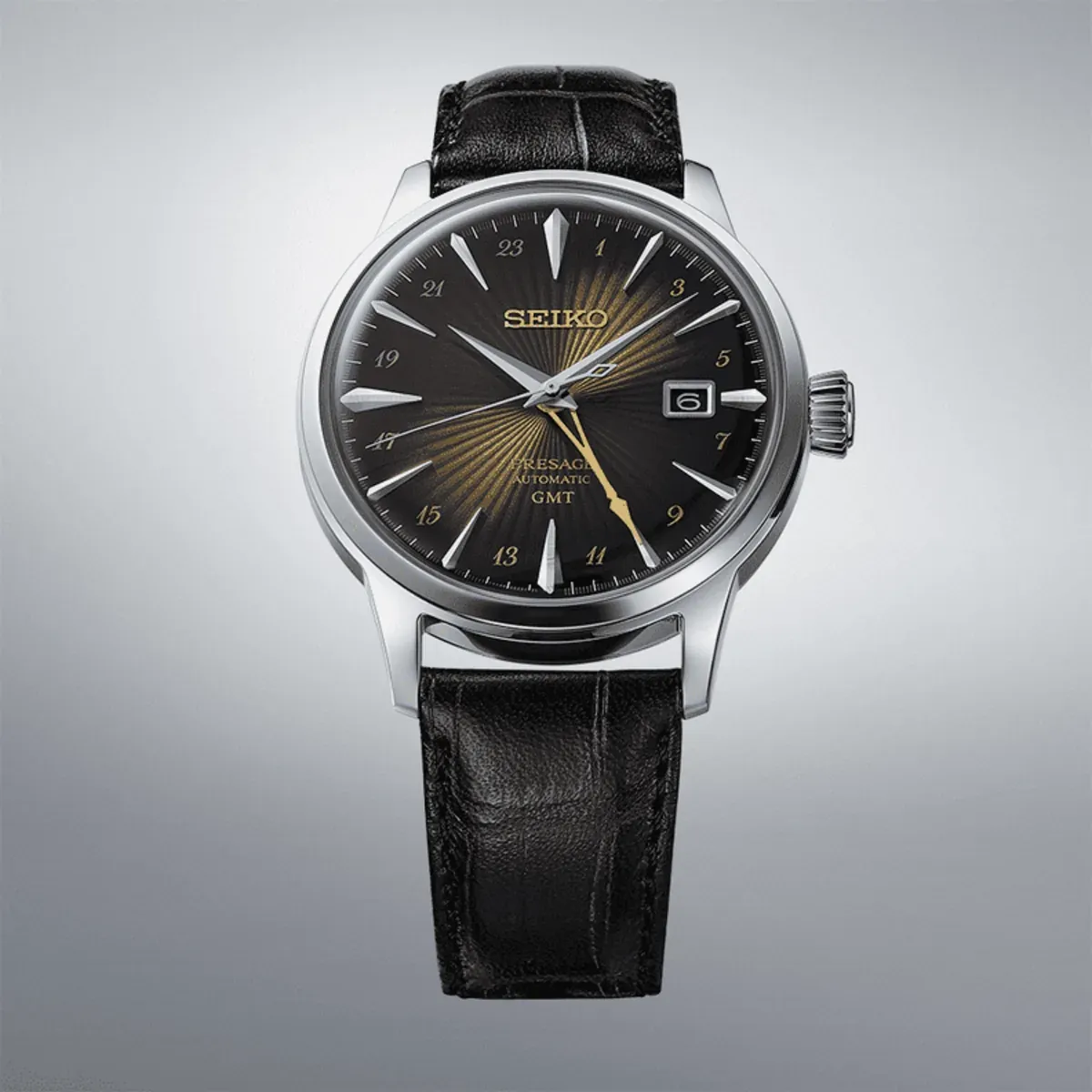 Vista frontal completa del reloj, centrado sobre fondo gris neutro con degradado.