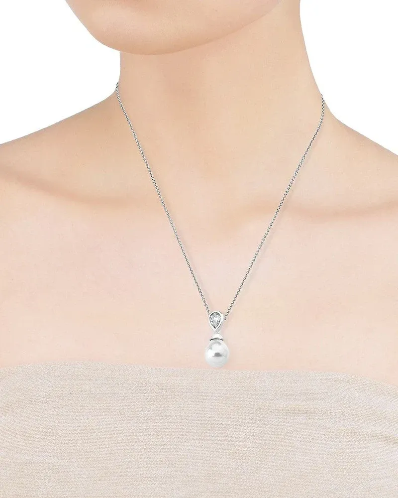 Primer plano del colgante de perla y circonita sobre el cuello de una modelo, toma frontal con fondo neutro.