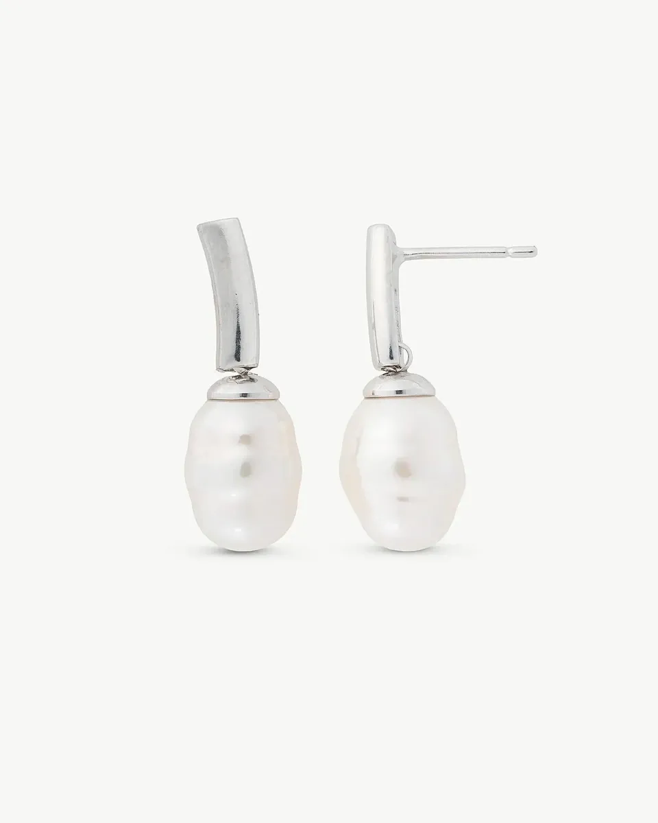 Pareja de pendientes de perla barroca con cierre de espiga en plata, vista frontal sobre fondo blanco.