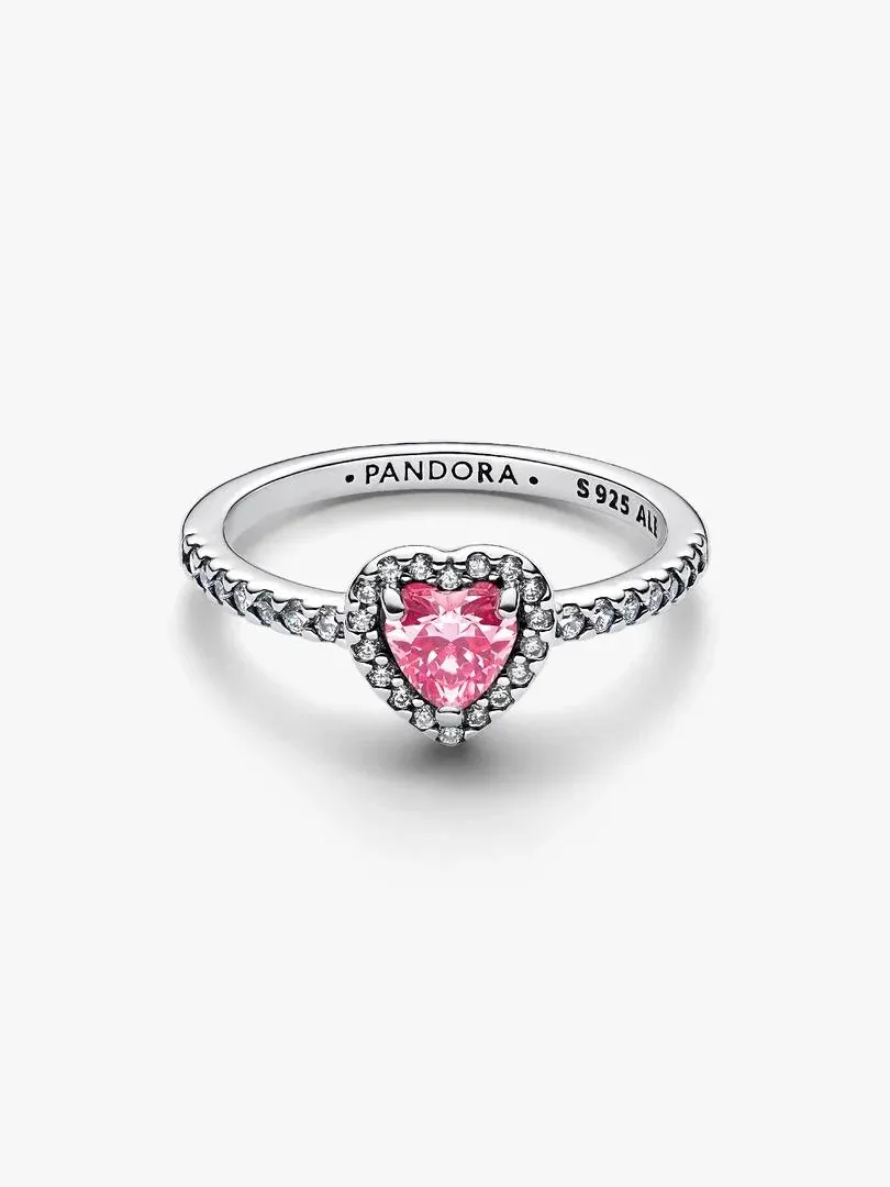 Pink heart ring shown from a side angle, white background, detail of pavé setting and engraved brand name.