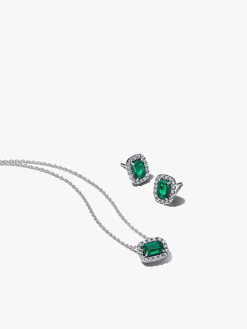 Necklace and earring set with green stones on a white background, high-angle shot.