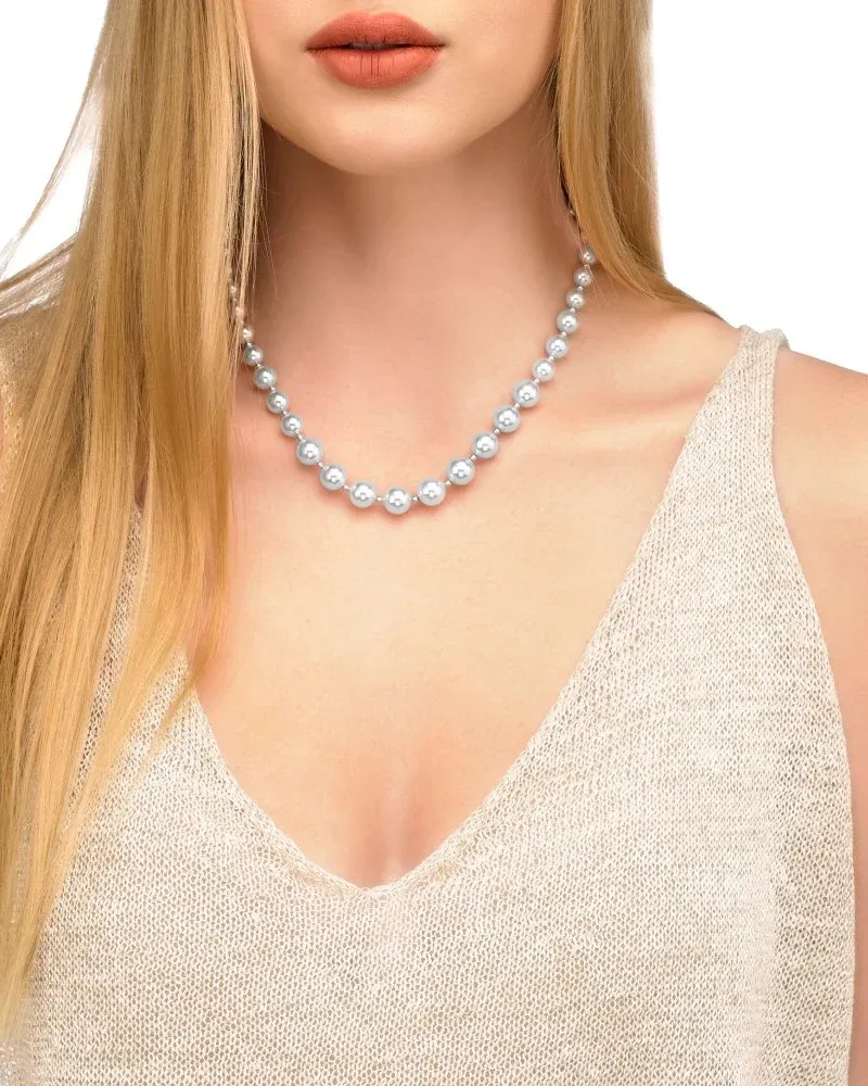 Primer plano del collar de perlas sobre el cuello de una modelo, toma frontal con escote en V.
