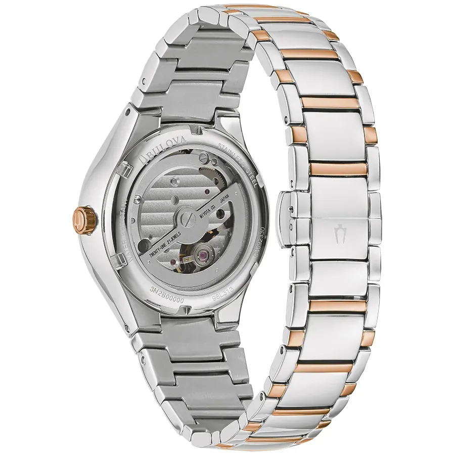 Vue arrière de la montre sur fond blanc, détail du mouvement mécanique et bracelet bicolore.