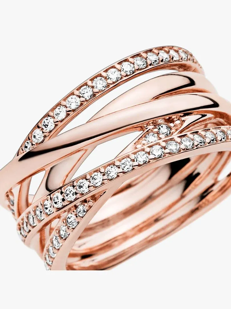 Angled close-up of intertwined ring with cubic zirconia, white background.