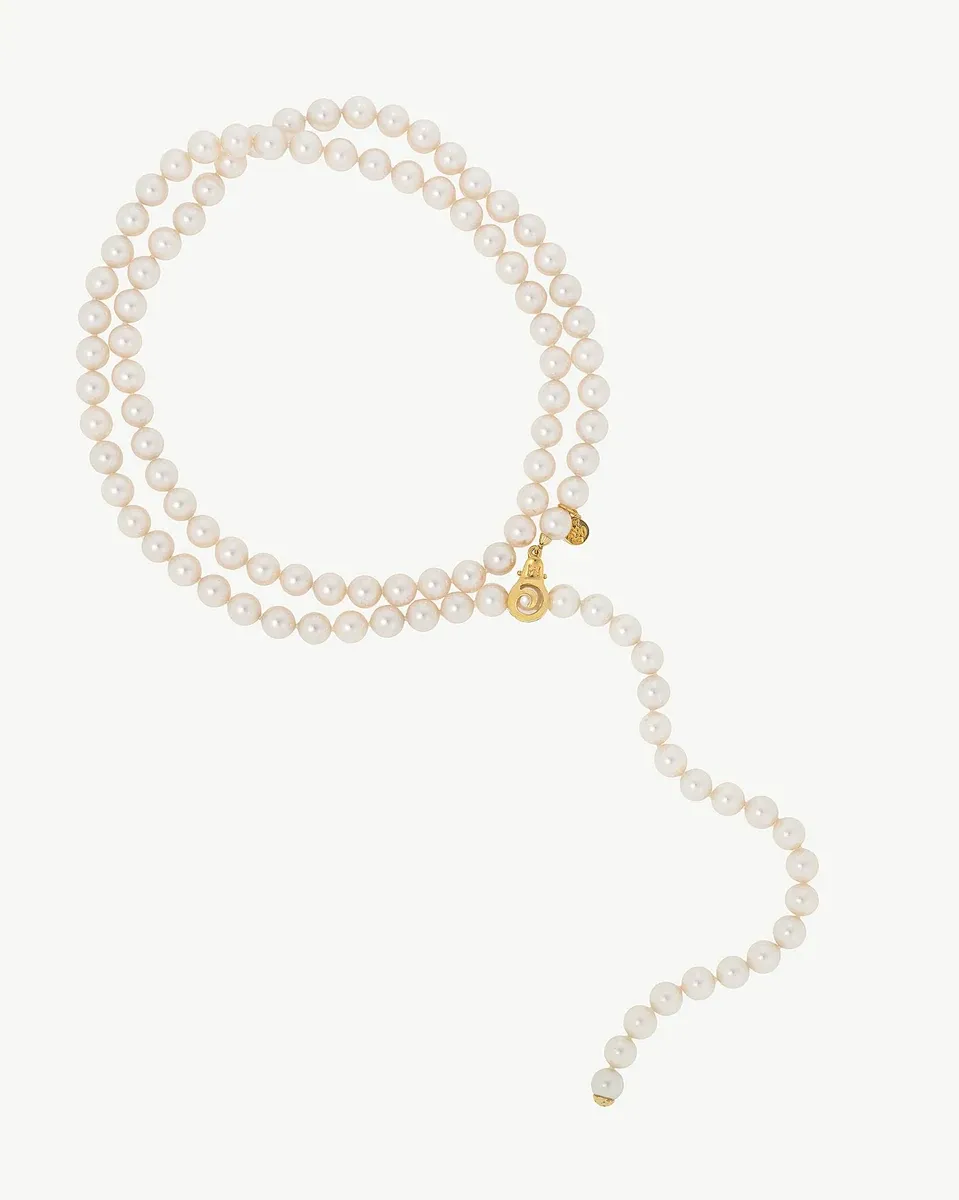 Collar de perlas blancas dispuesto en forma de lazo sobre fondo blanco, vista frontal completa.