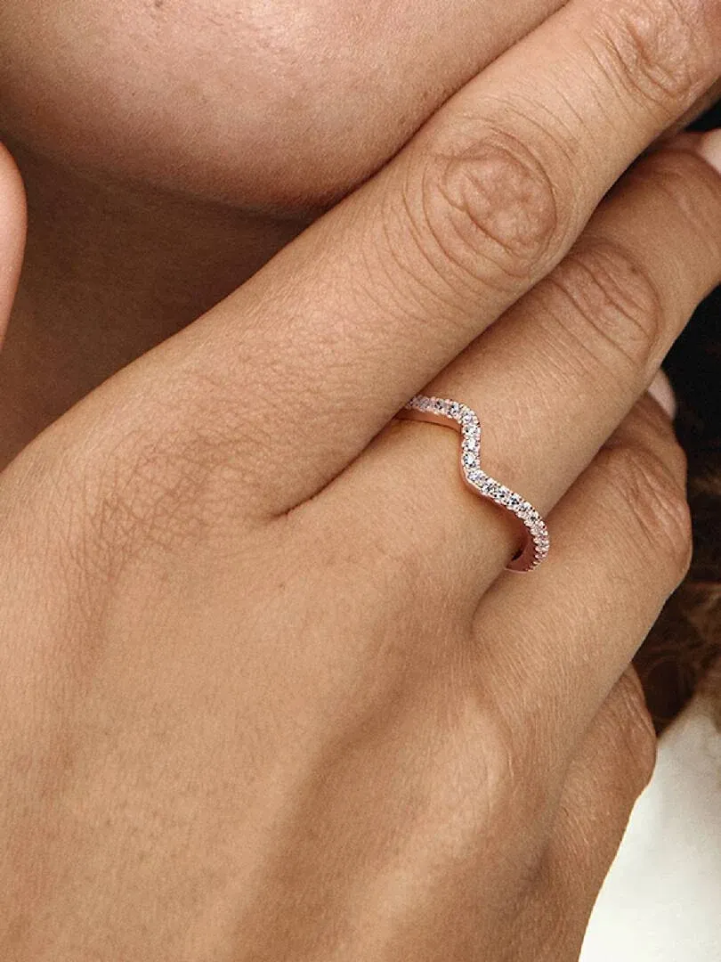 Primer plano del anillo ondulado con circonitas puesto en el dedo, toma lateral sobre la mano.