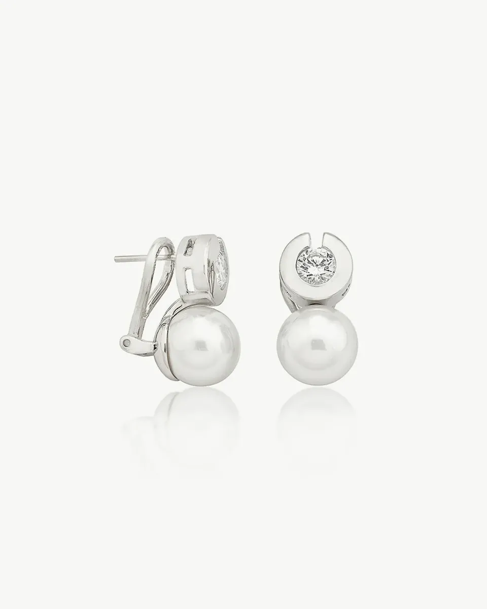 Paire de boucles d'oreilles en perles blanches et zirconiums, vue de face sur fond blanc avec reflet.