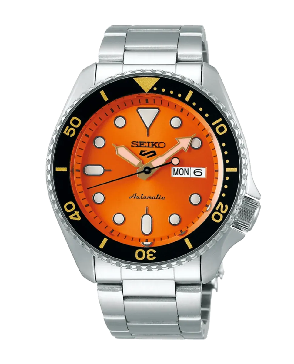 Vista frontal centrada del reloj con esfera naranja y brazalete de acero, sobre fondo blanco.