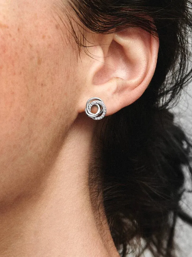 Seitenansicht in Nahaufnahme eines Steckohrrings mit drei ineinander verschlungenen Ringen am Ohrläppchen.