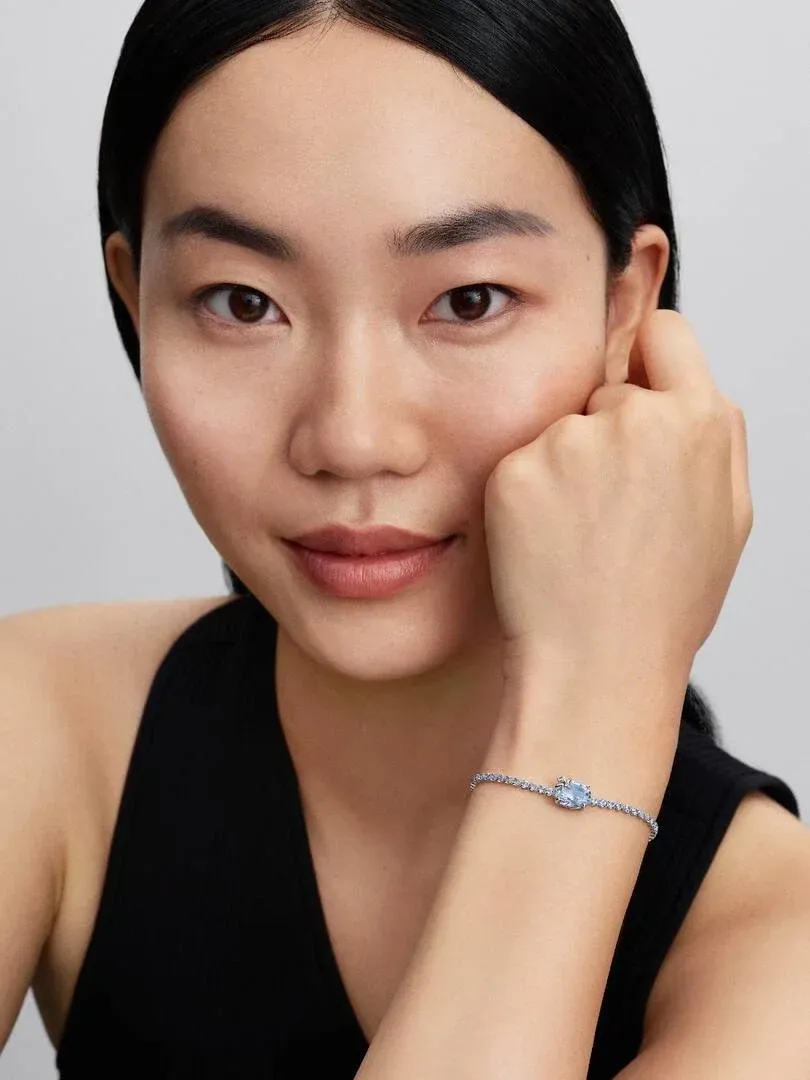 Gros plan du bracelet au poignet, vue de profil avec modèle sur fond neutre.