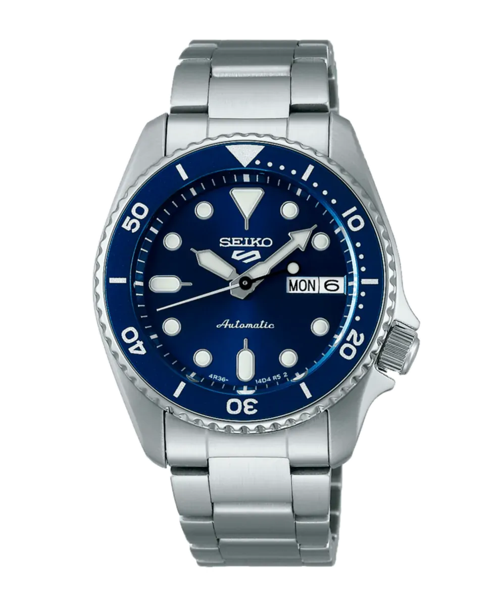 Vista frontal del reloj con esfera azul y brazalete de acero, centrado sobre fondo blanco.