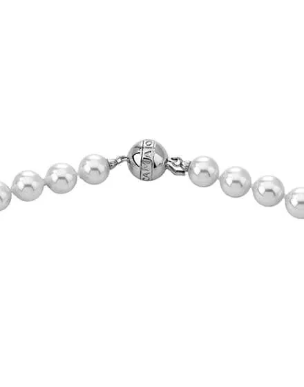 Close-up van de zilveren sluiting met logo en ronde witte parels op een witte achtergrond.