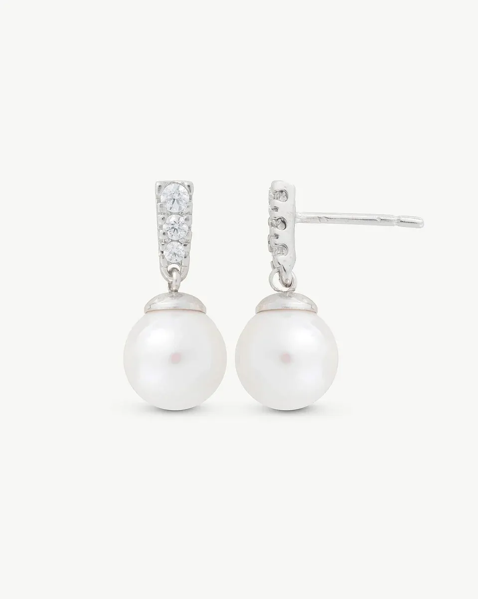Vue de face des boucles d'oreilles en perles et zircons sur fond blanc.