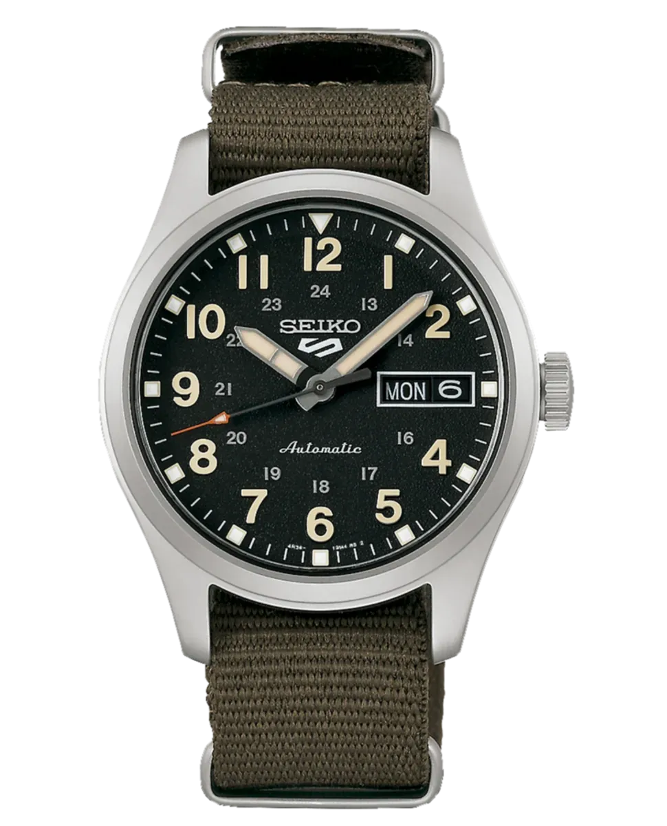 Vista frontal del reloj con esfera negra y correa de nylon verde caqui, fondo blanco.