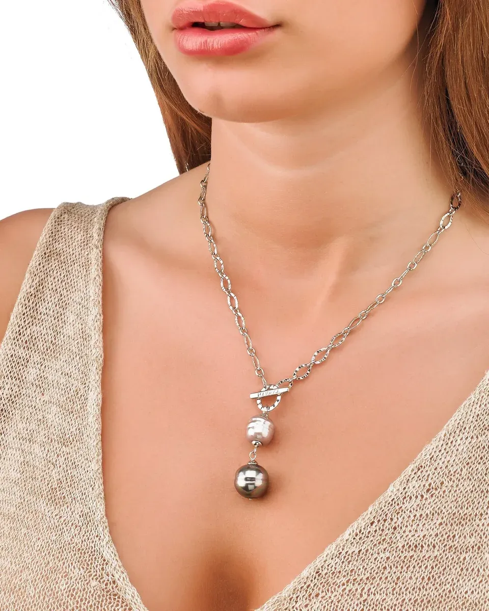 Primer plano del collar con perlas barrocas sobre el cuello de una modelo, toma frontal con escote en V.
