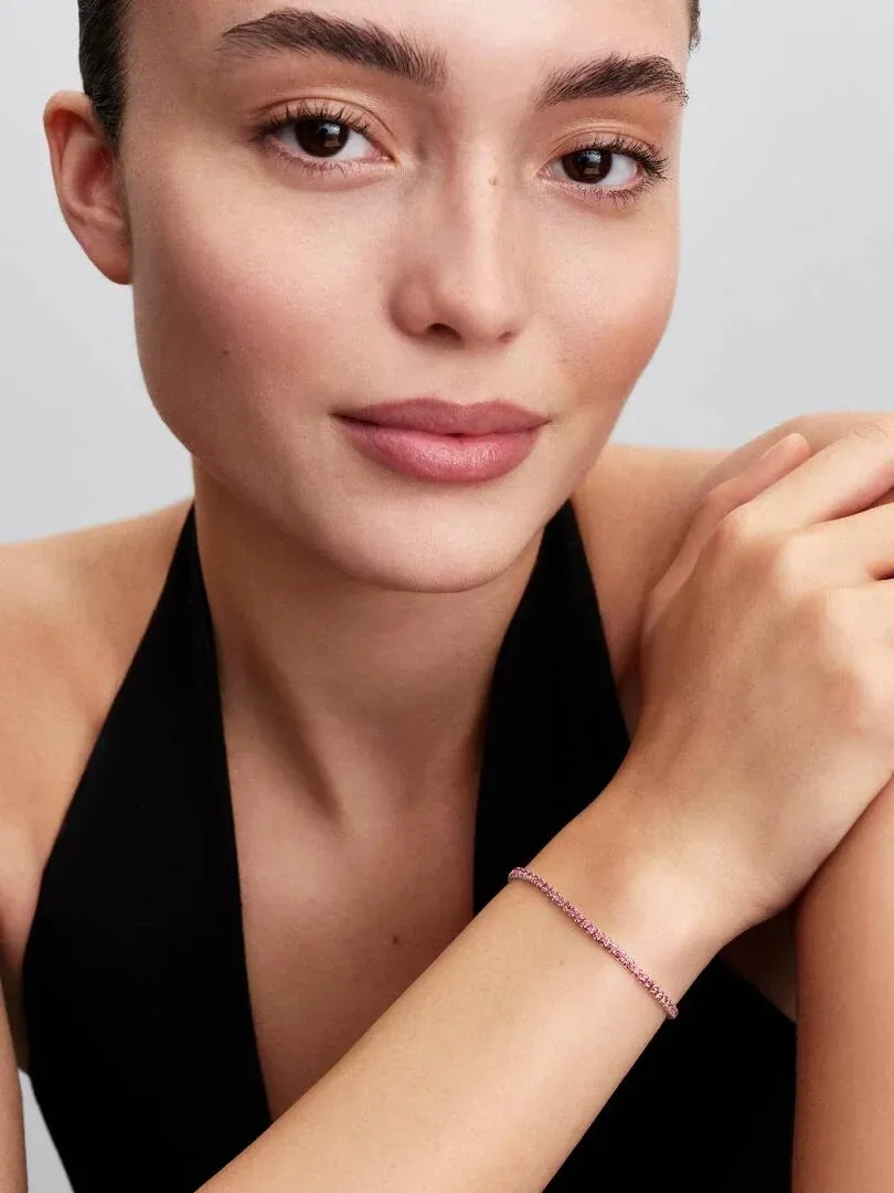 Close-up van de armband om de pols van een model, zijaanzicht met een wazige neutrale achtergrond.