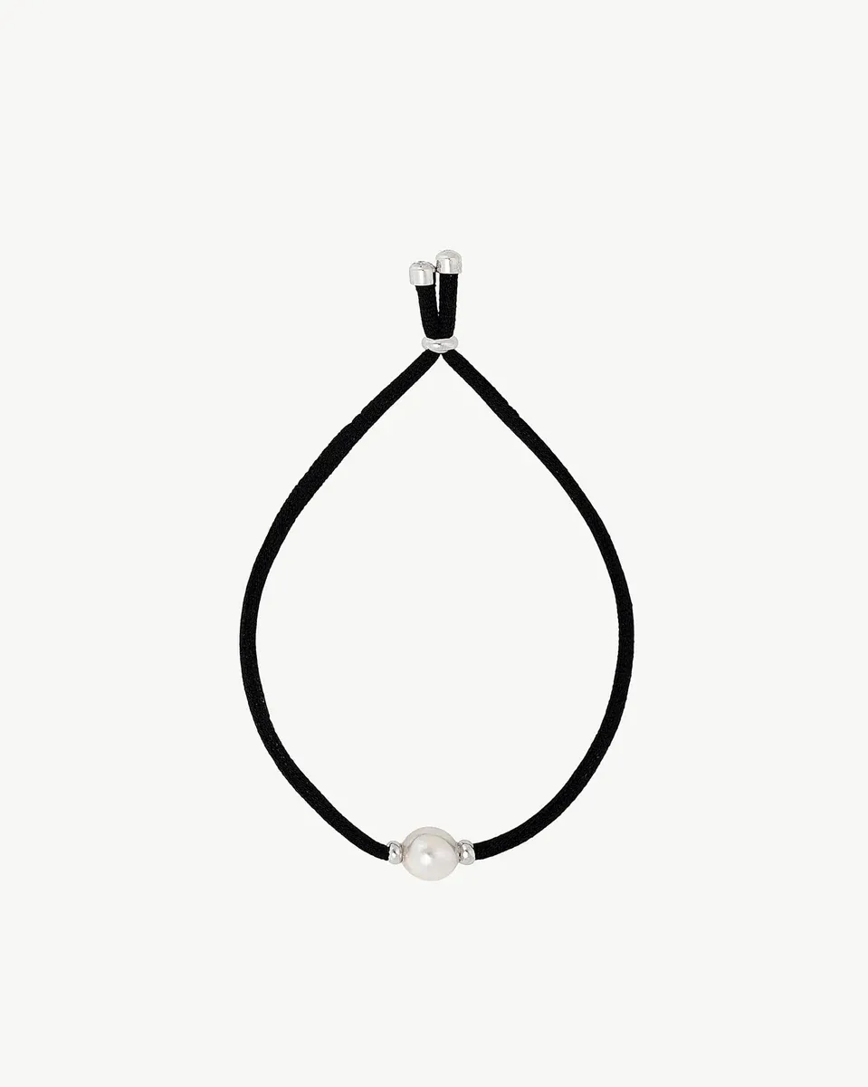 Pulsera negra con perla blanca vista de frente, disposición circular sobre fondo blanco.