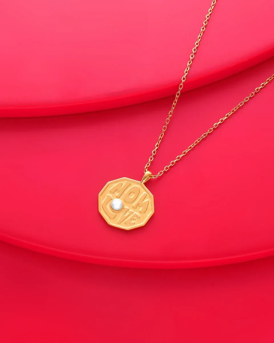 Gouden medaillon ketting op een levendige rode achtergrond, vooraanzicht vanuit een hoge hoek.