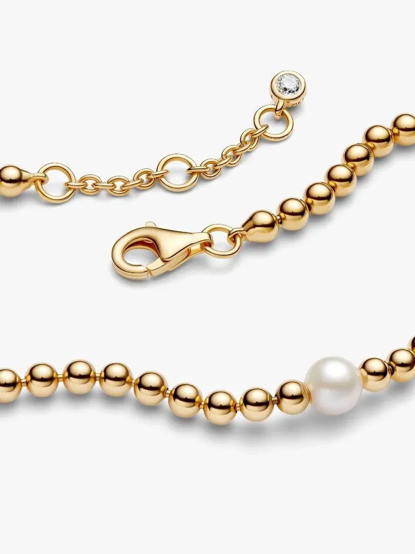 Gros plan du bracelet à perle et du fermoir mousqueton avec zircon sur fond blanc.