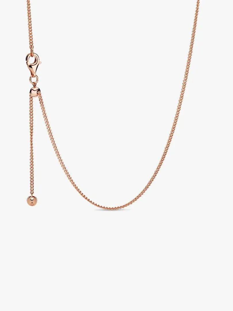 Nahaufnahme des roségoldenen Schiebeverschlusses und der Curb-Kette auf weißem Hintergrund.