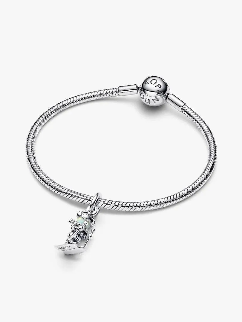 Charm skieur suspendu à un bracelet en argent, vue de profil sur fond blanc.