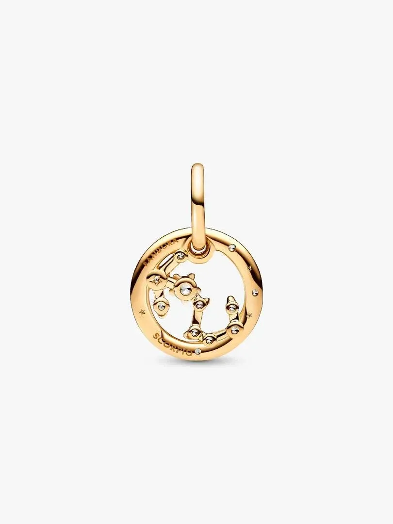 Charm circular dorado con detalle de Escorpio y circonitas, visto de frente sobre fondo blanco.