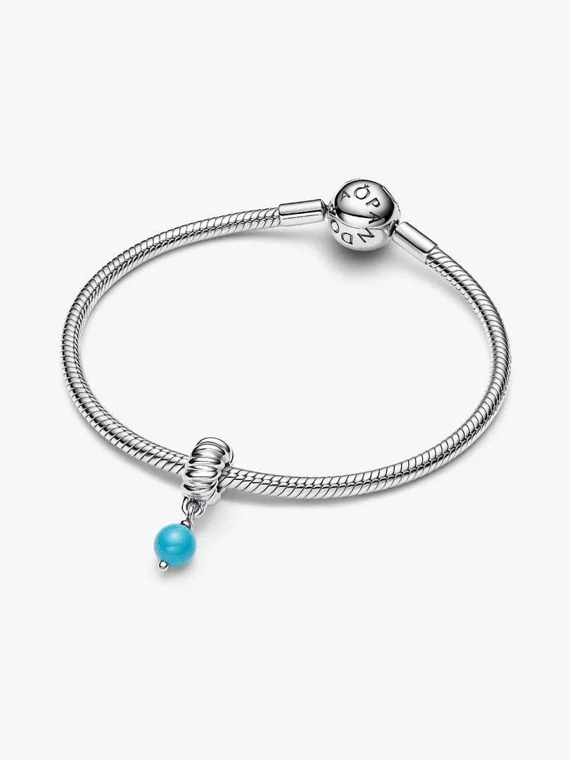 Zilveren armband met turquoise charm, vooraanzicht onder een hoek op witte achtergrond.
