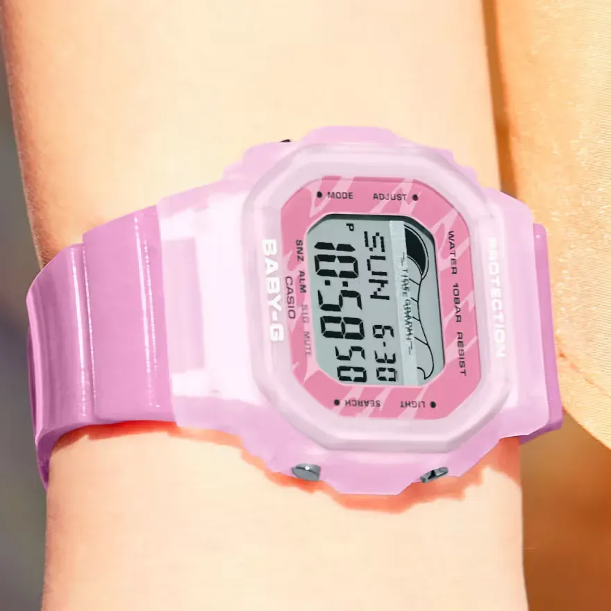 Primer plano del reloj digital rosa puesto en la muñeca, vista frontal sobre piel.