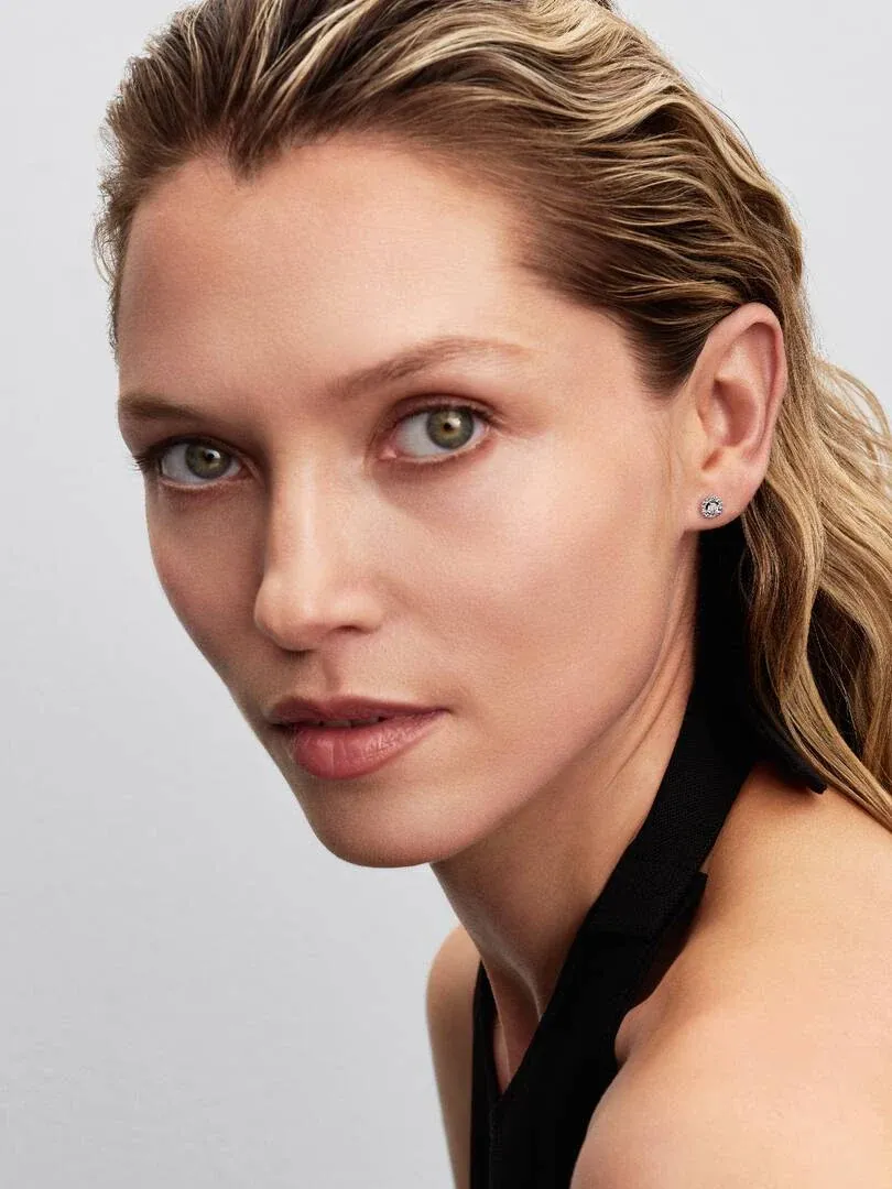 Close-up van een oorring met zirkonia op het oorlel van een model, vooraanzicht.