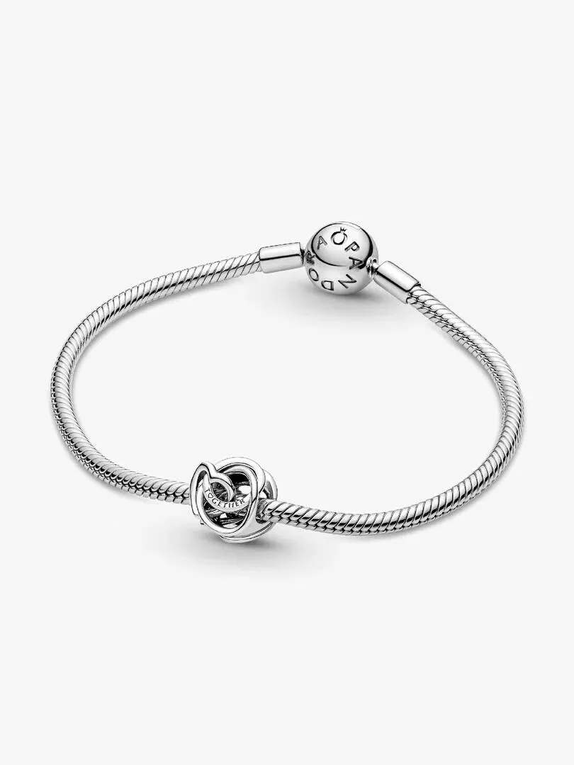 Bracelet en argent avec charm cœur entrelacé, vue de face sur fond blanc.