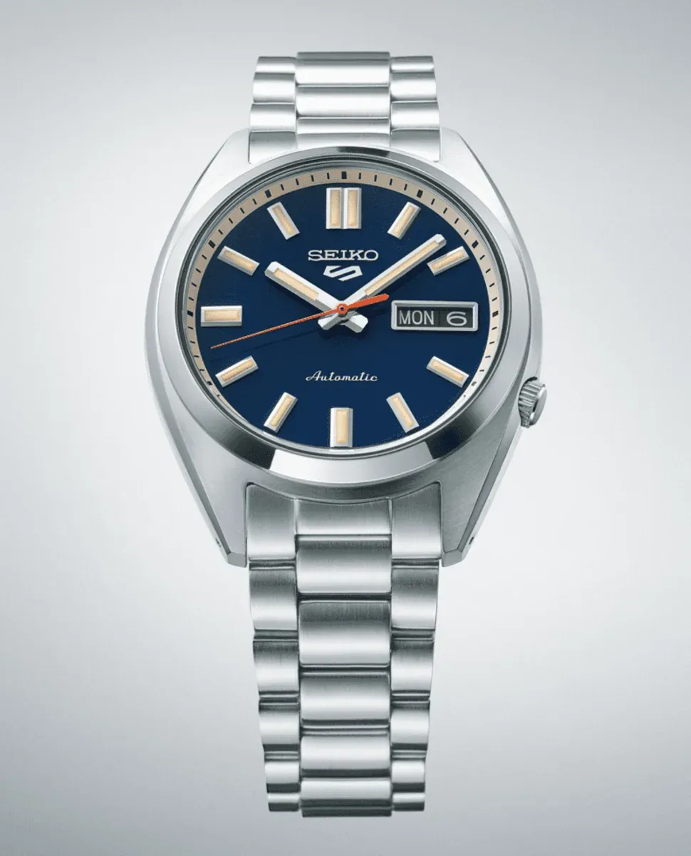 Vue de face centrée de la montre sur fond neutre, montrant le cadran bleu et le bracelet en acier.