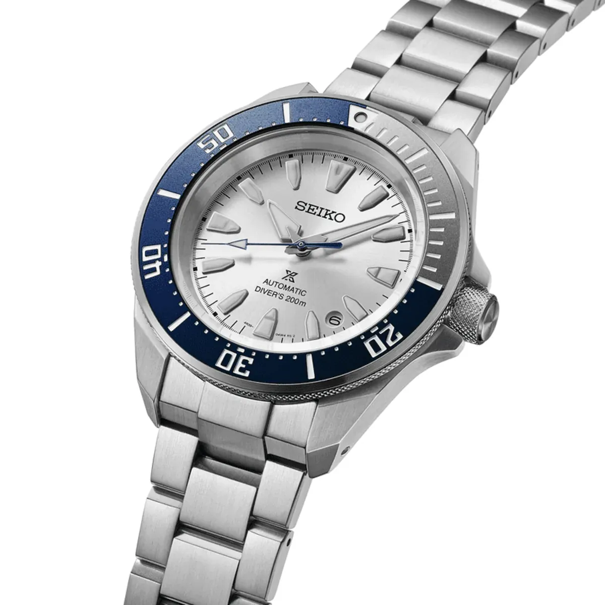Vista en perspectiva del reloj sobre fondo blanco, destacando el bisel azul y el brazalete de acero.