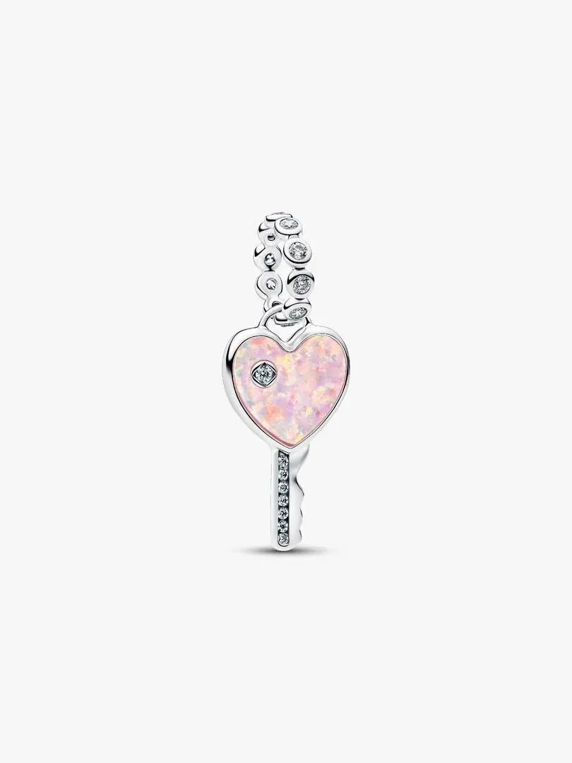 Charm de llave con corazón rosa visto de frente, sobre fondo blanco puro.