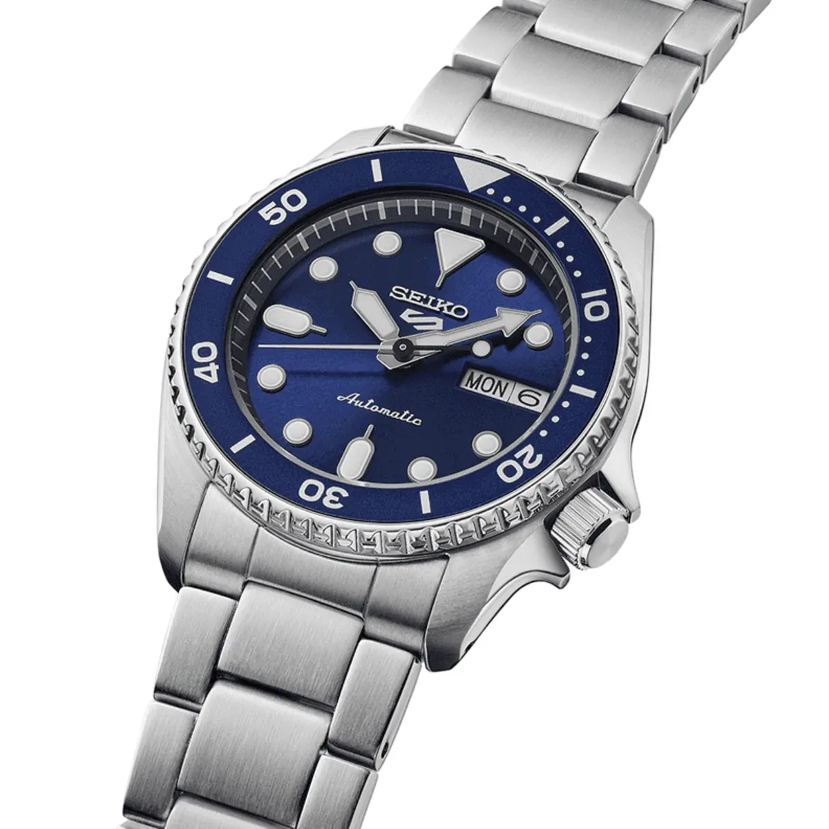Vista en perspectiva del reloj sobre fondo blanco, mostrando la esfera azul y el lateral de la caja con la corona.