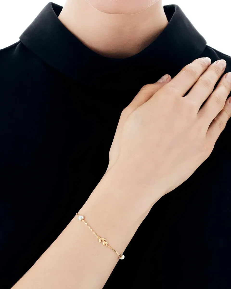 Close-up van de armband om de pols, zijaanzicht tegen witte achtergrond en zwarte kleding.