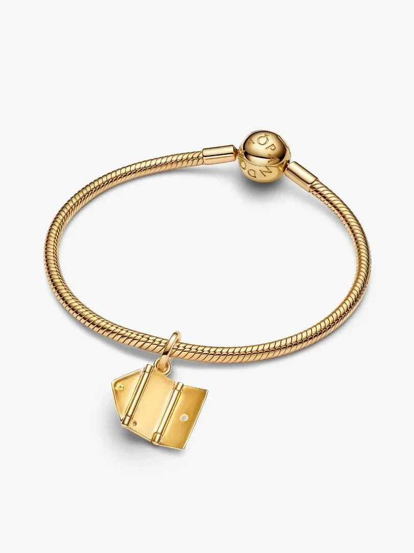 Gouden envelop charm aan een armband, vooraanzicht met een licht hoog camerastandpunt, witte achtergrond.