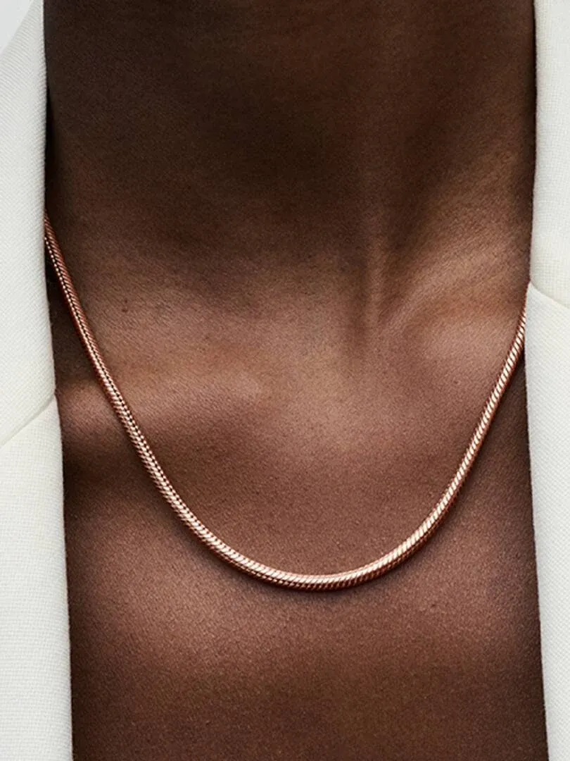 Close-up of the chain necklace worn on a model's neck and chest, front view against a white background.