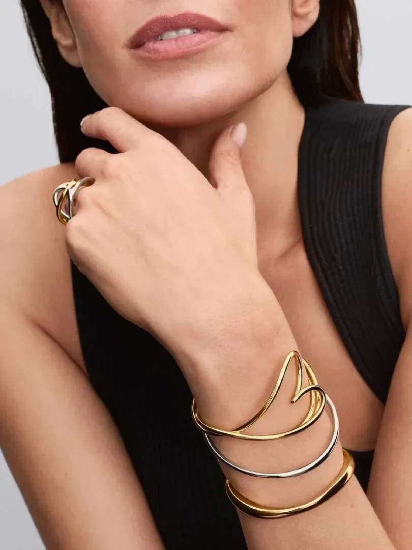 Nahaufnahme des herzförmigen Armreifs am Handgelenk und passender Ring, getragen von einem Model.