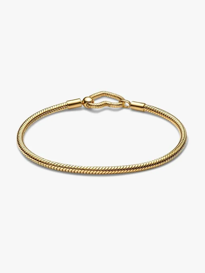Slangarmband in een hoek, met gouden hartsluiting op een witte achtergrond.