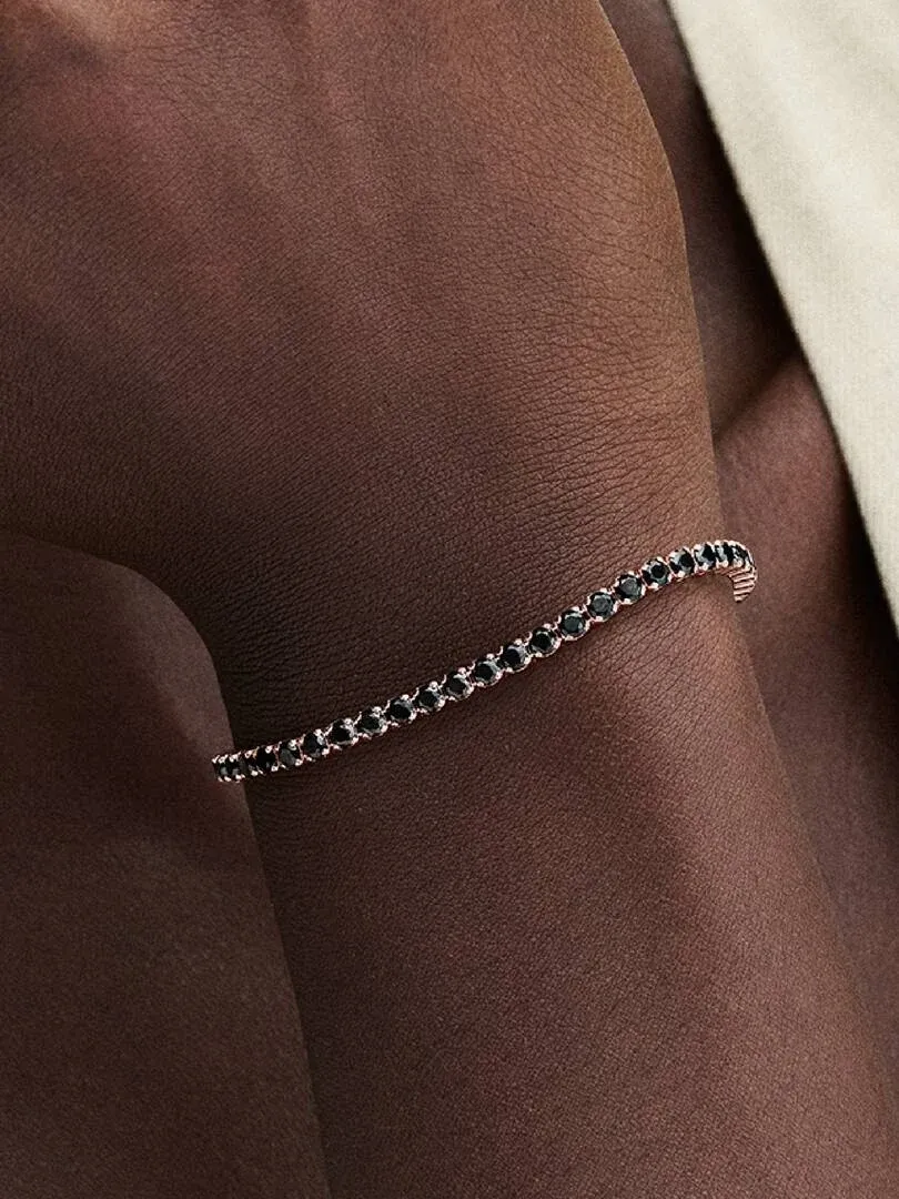 Nahaufnahme des Tennisarmbands mit schwarzen Kristallen am Handgelenk, Seitenansicht.