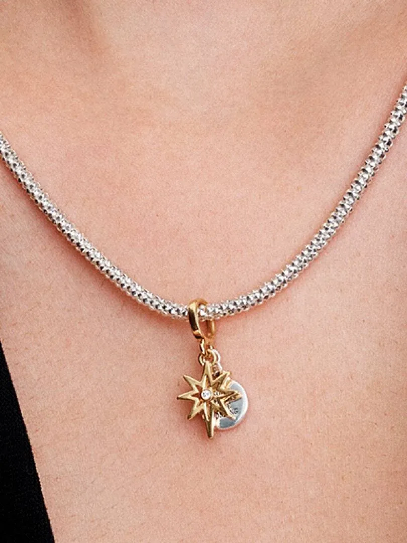 Close-up of the North Star charm on skin, front view with a silver chain necklace.